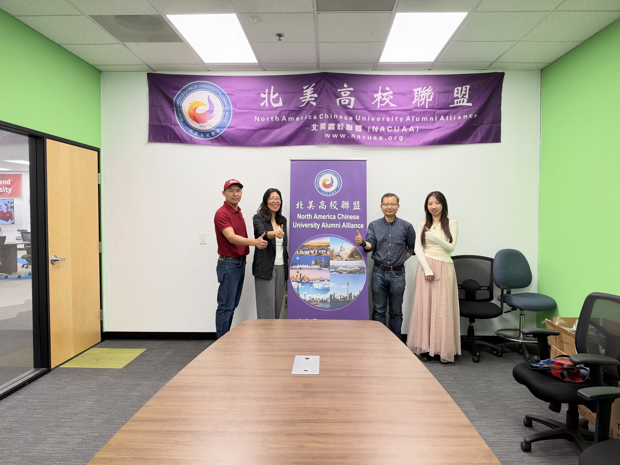 Attendees posing in front of the NACUAA banner